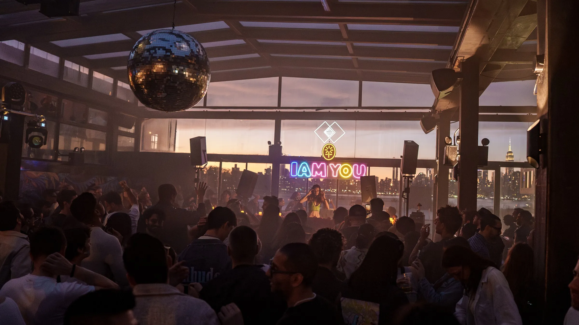 The illuminated I AM YOU sign above the dance floor at sunset