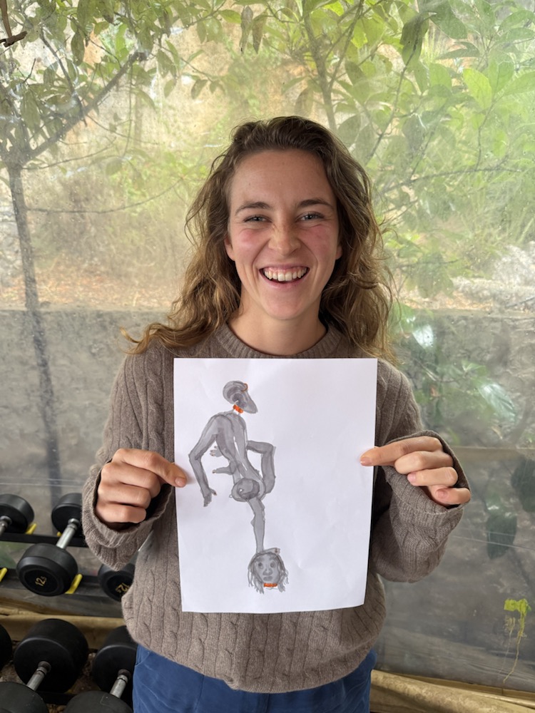 Participant holding a grey, long-limbed alien drawing