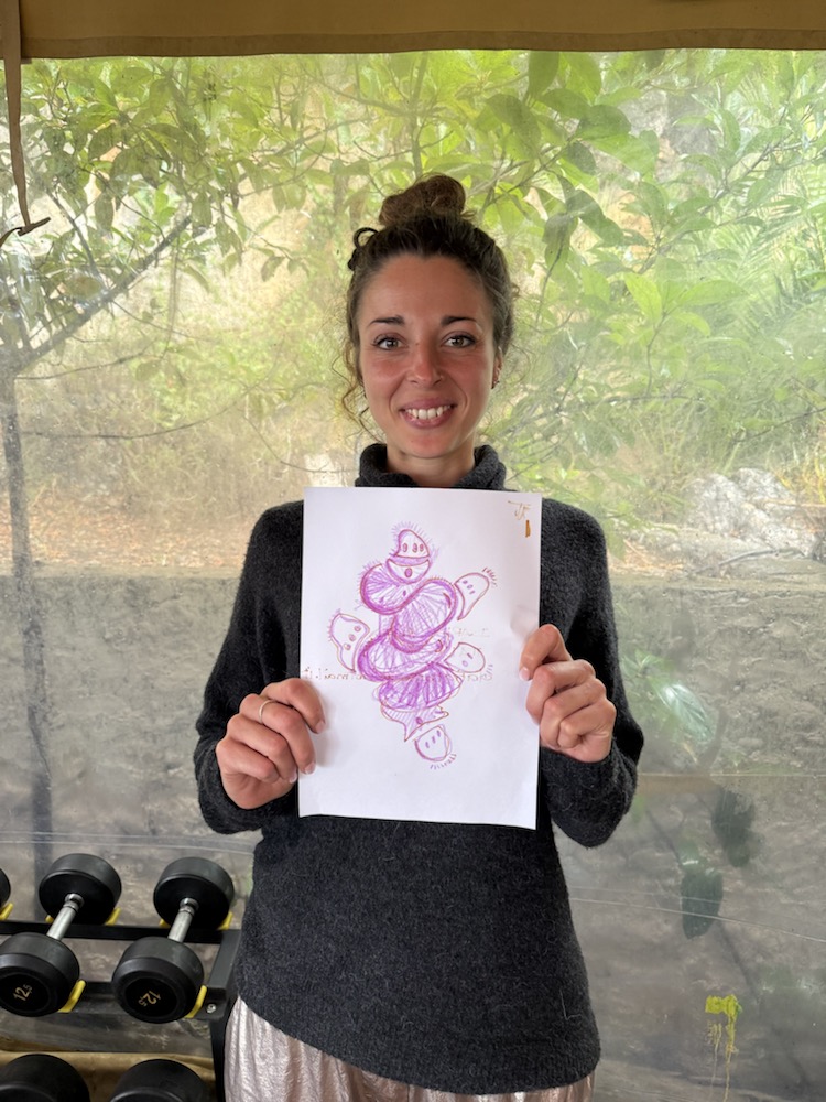 Participant holding a pink alien drawing