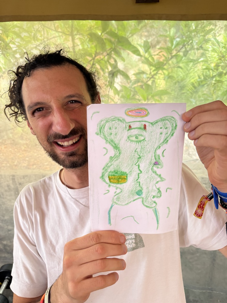 Participant holding a green alien drawing
