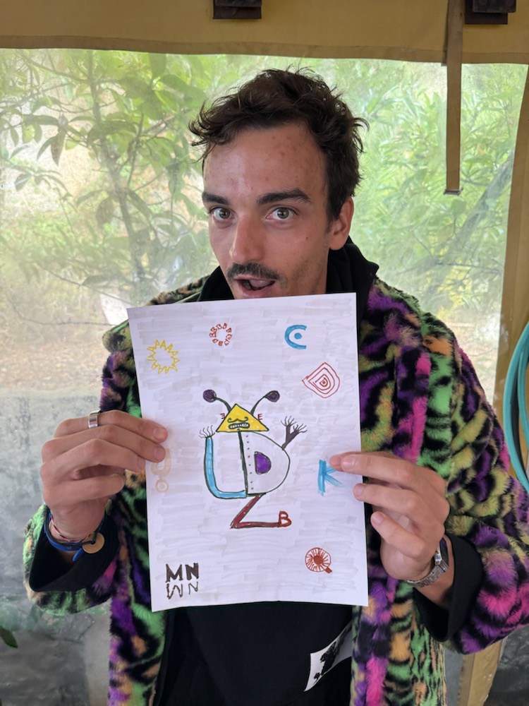 Participant holding a geometric alien drawing