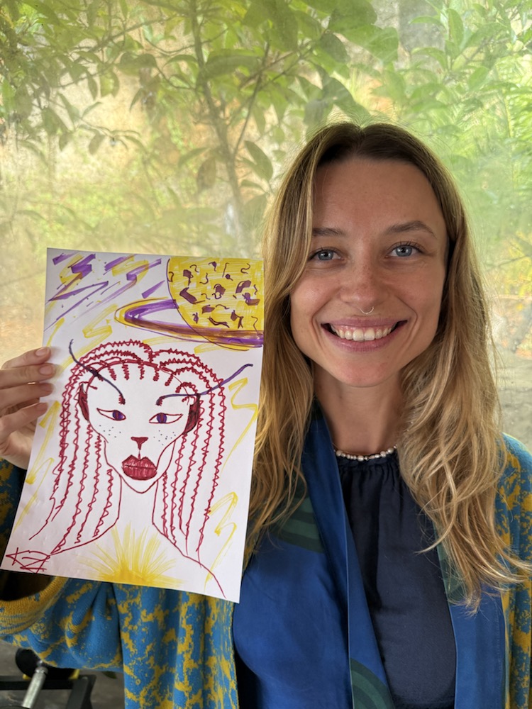 Participant holding a red and yellow alien drawing